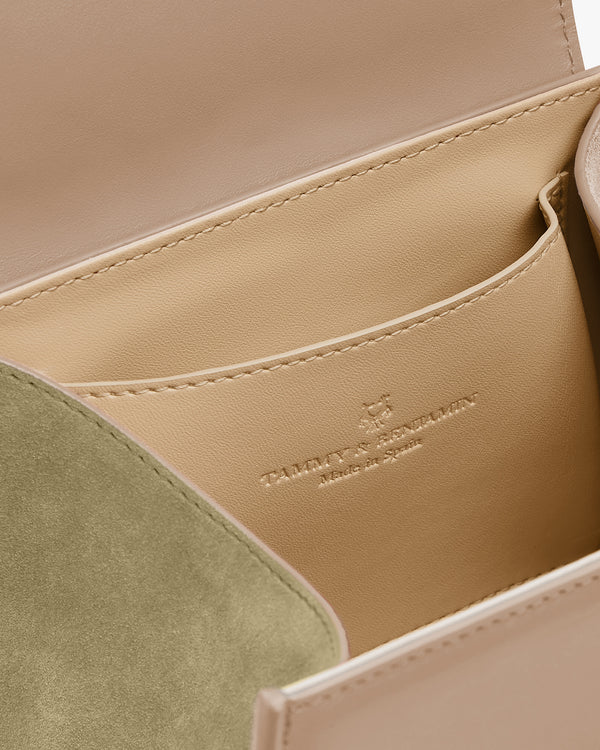 Sac ALEXIA NANO Beige, intérieur ouvert, poche plaquée et rabat en suède vert, logo gaufré visible