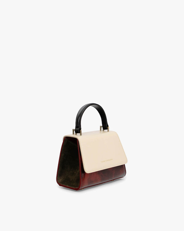 Sac ALEXIA NANO Colourblock art déco, vue de trois quarts, poignée noire, rabat écru et corps bordeaux