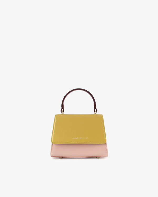 Sac ALEXIA NANO Colourblock Vesper de face, rabat jaune moutarde, corps rose, poignée bordeaux