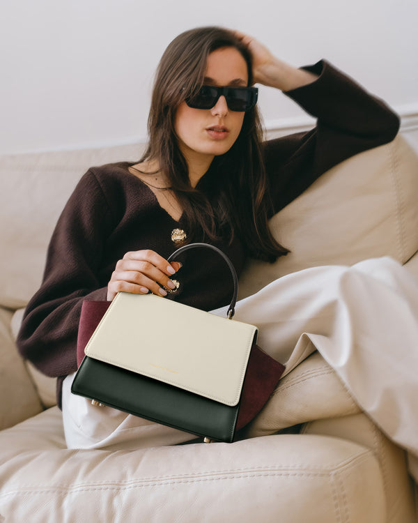 Sac ALEXIA Colourblock Canopé tenu à la main, poignée gainée, porté assis sur un canapé
