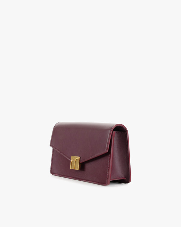 ELEANOR bag in Aubergine, three-quarter side view, gold Marble Arch clasp, standing