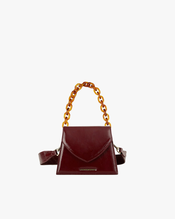 Sac GABRIELLE en cuir naplak bordeaux, vue de face, anse chaîne détachable, posé
