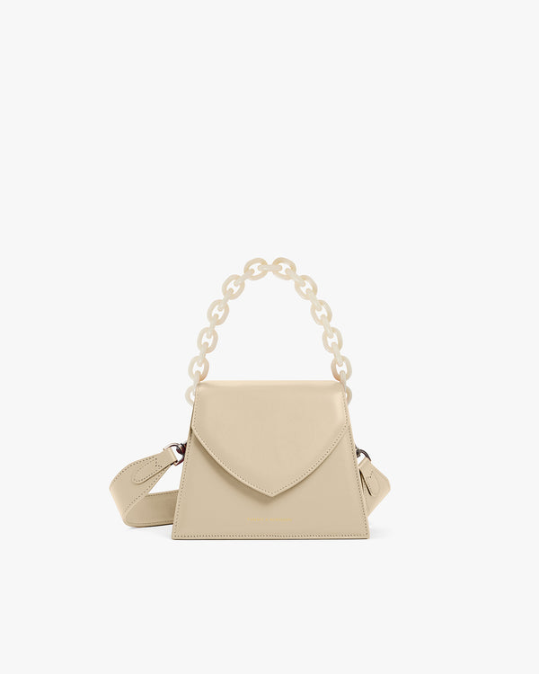 Sac GABRIELLE beige de face, posé, avec anse chaîne courte et bandoulière en cuir