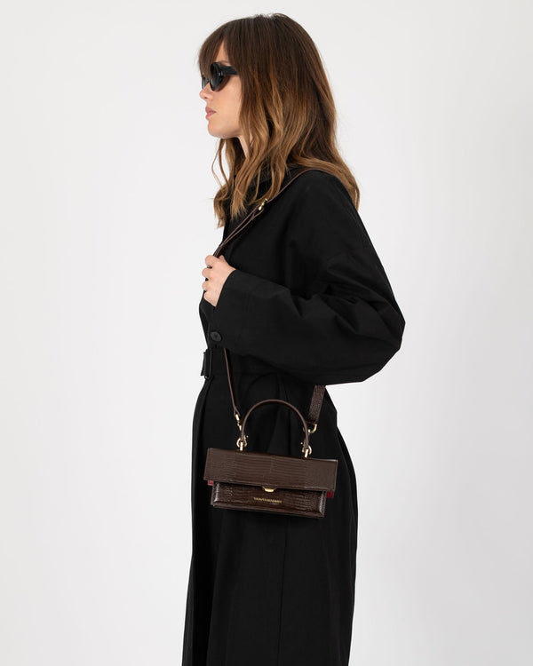 THEA MINI bag in brown embossed lizard, worn crossbody, side view