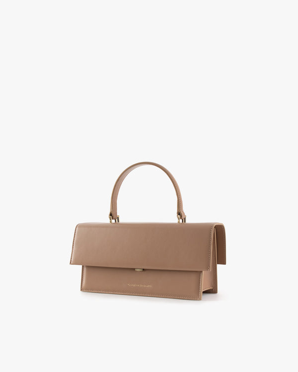 THEA bag in Beige, three-quarter view, closed flap, rigid handle, placed on white background