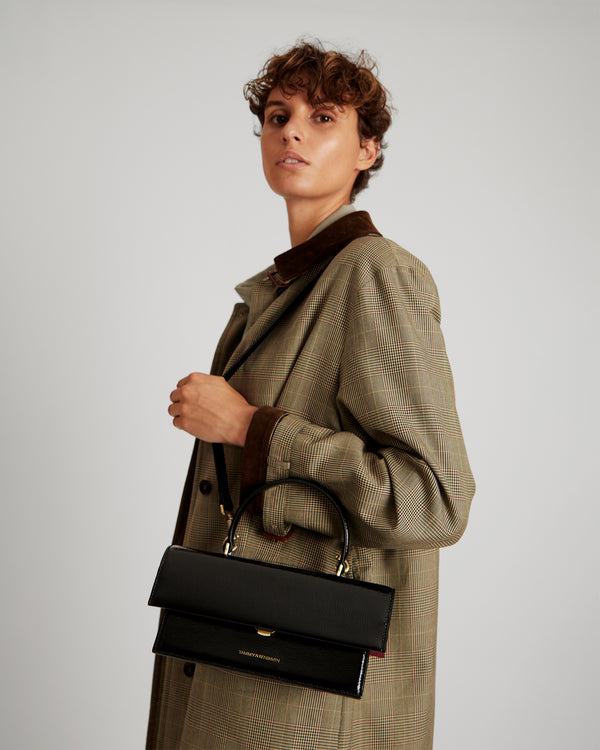 Sac THEA noir naplak porté à l'épaule avec poignée rigide, vue de profil sur un mannequin