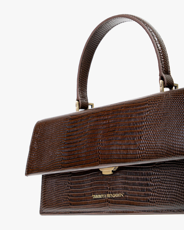 THEA bag in brown embossed lizard, close-up on handle, flap and gold clasp