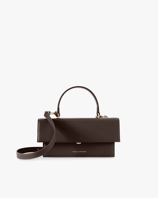 THEA bag in Chocolate, front view, flap closed, shown with top handle and detached shoulder strap
