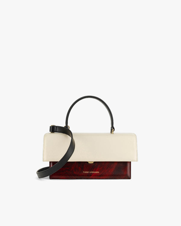 Sac THEA Colourblock art déco de face, rabat écru, base rouge veinée, anse noire et bandoulière