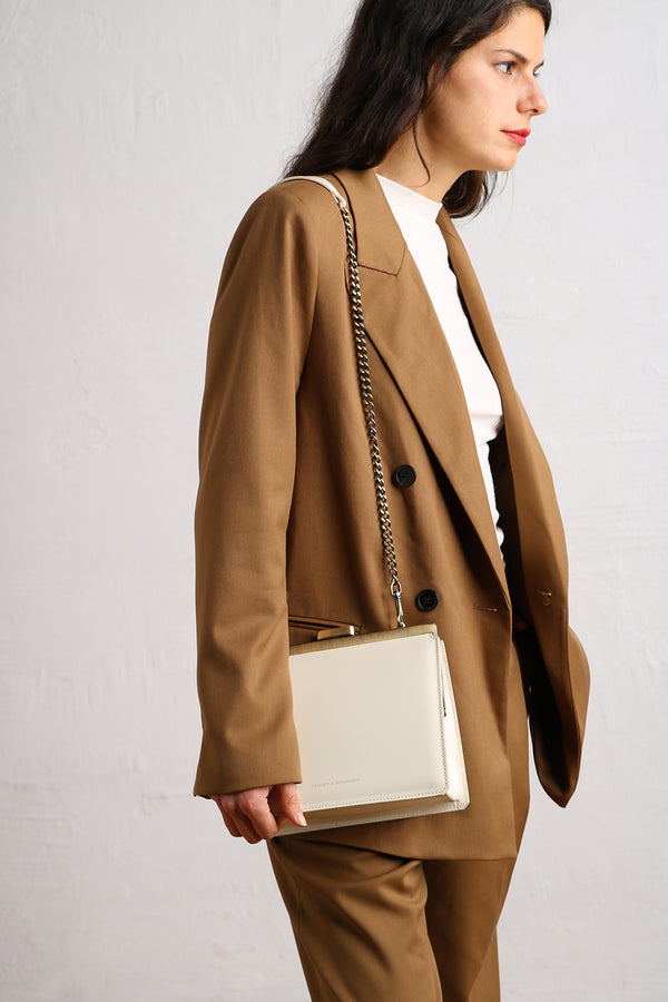 JEANNE bag in Ivory worn crossbody with chain strap, side view on camel blazer
