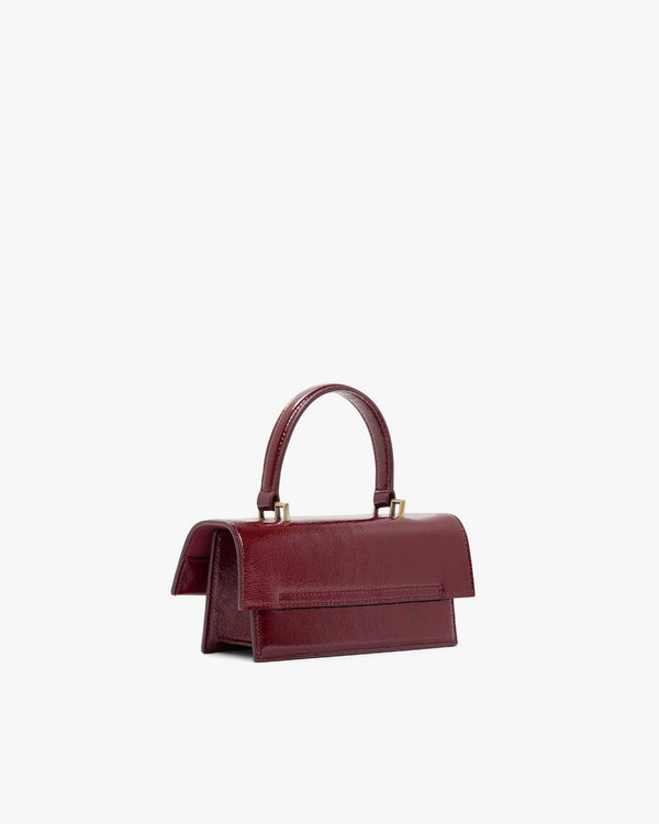 Sac THEA MINI en naplak bordeaux, vue de trois quarts arrière, posé, anse courte relevée
