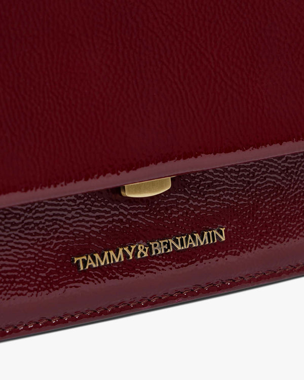 Sac THEA MINI Bordeaux naplak, détail du fermoir doré et du logo gravé sur le rabat