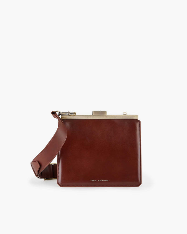 JEANNE bag in brown, front view, closed metal clasp, adjustable strap resting to the side