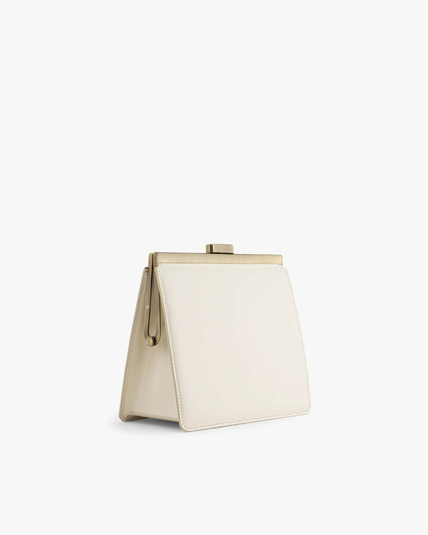 JEANNE bag in Ivory, side view, standing, showing gold-tone clasp and removable strap